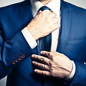 Man adjusting his tuxedo tie.